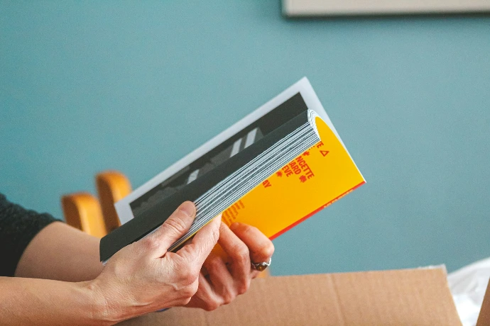 Hands holding a book with a yellow cover